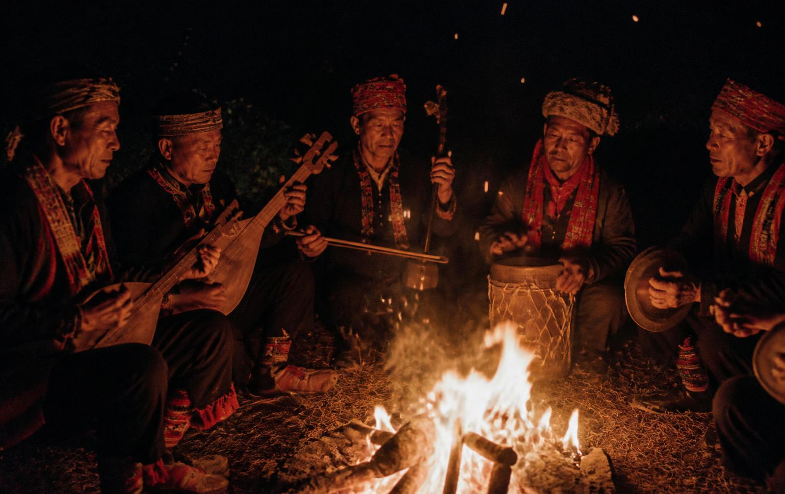 Musicians performing by firelight in Northeast India